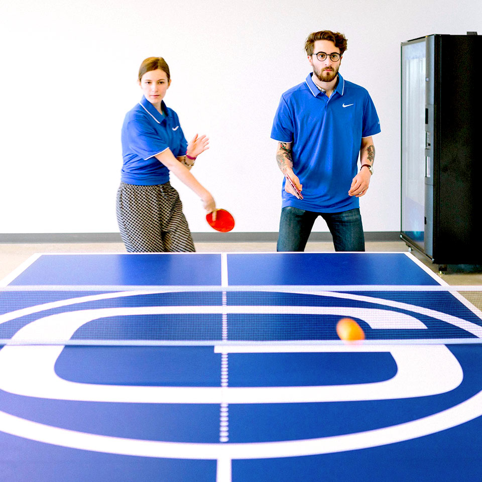 Two concentrated Geotab employees playing ping pong.