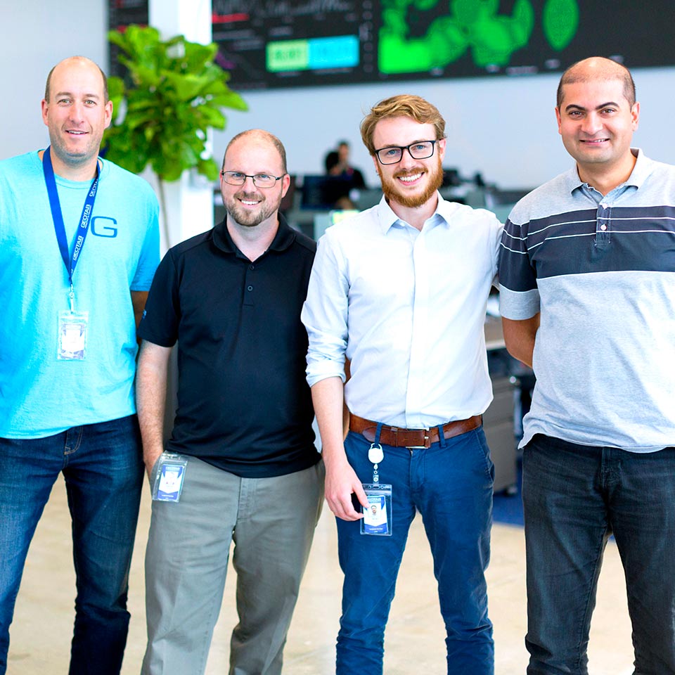 Five Geotab employees standing together smiling.