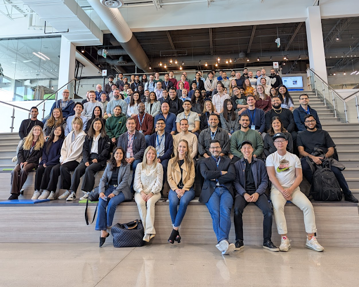A large group of Geotabbers posing for a group photo on wide stairs in the Geotab office