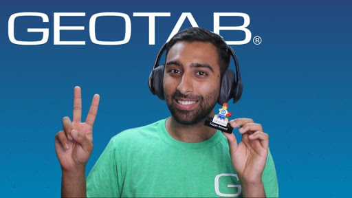 Geotab employee with green shirt holding Geotab device.