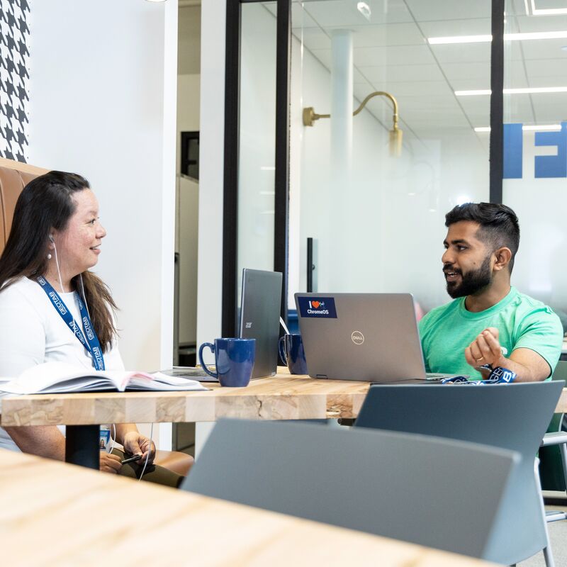 Geotab mentor in the green shirt help a new student
