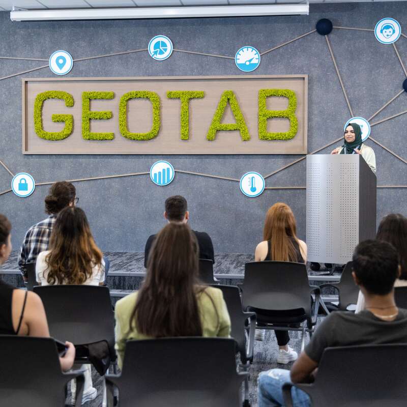 On the stage, one of the employees of the geotab makes a presentation for several people